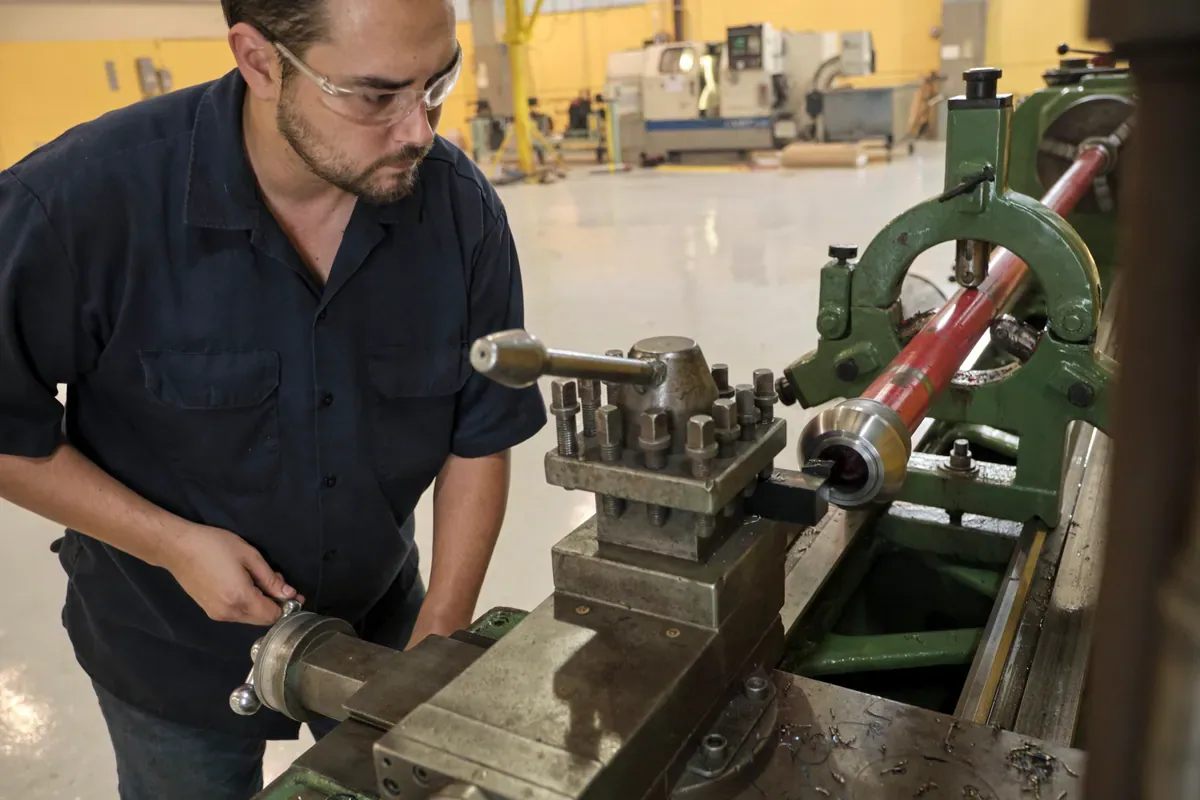 Cactus Flow Control technician machining a red iron component on a lathe